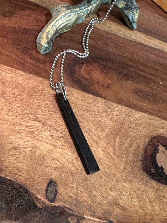 Ebony Pendant with chain on a wooden surface