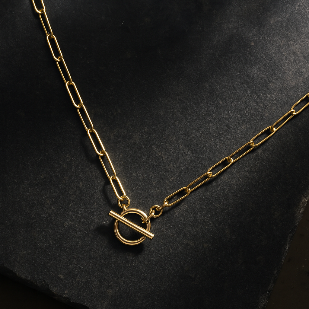 flat lay design of paperclip necklace on dark background granite