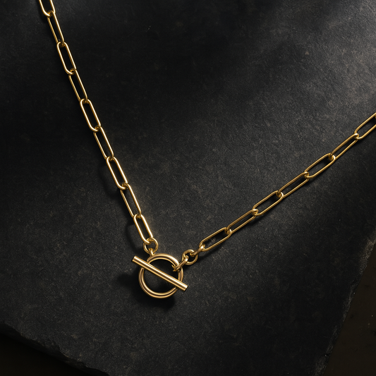 flat lay design of paperclip necklace on dark background granite