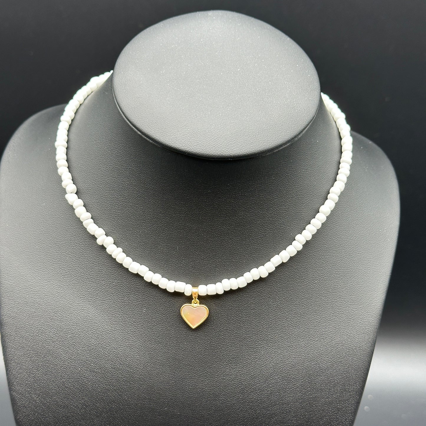 Necklace with white beaded chain and gold mother of pearl heart pendant