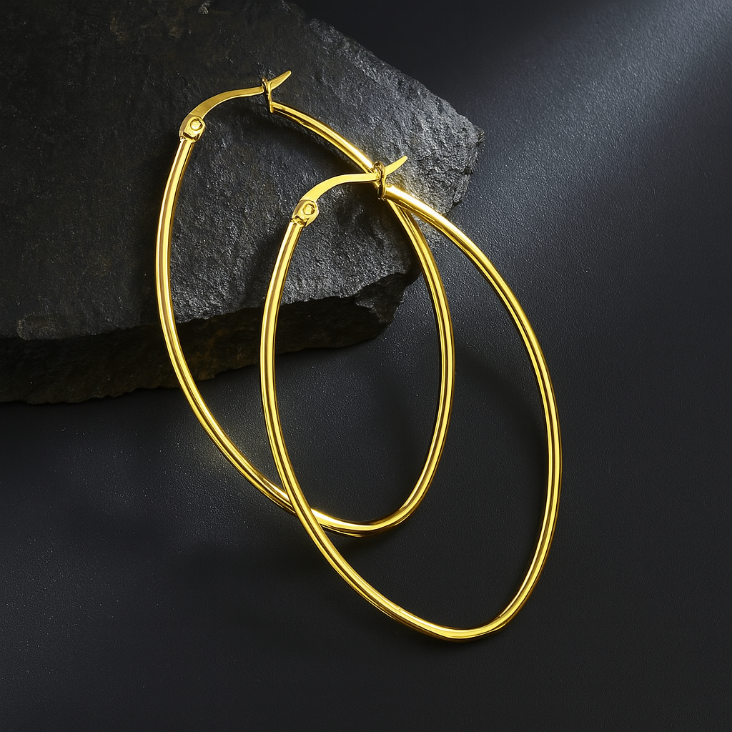 large gold oval hoop earrings on a background of black granite
