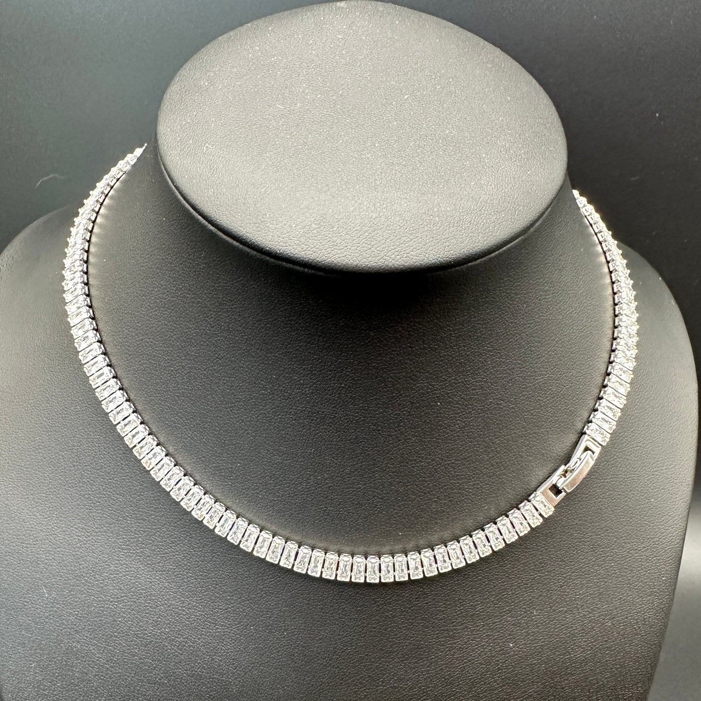 Silver necklace on a gray mannequin bust