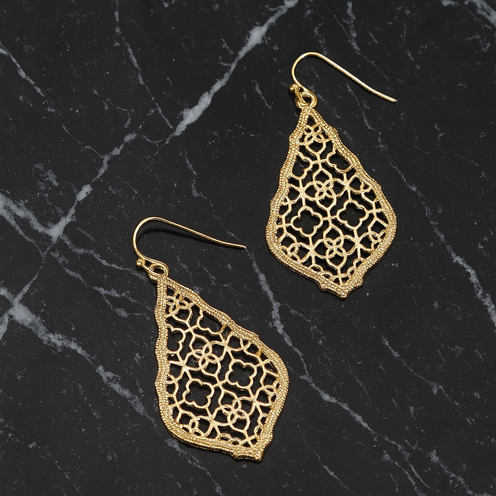 morrocan style gold earrings laying on a piece of black granite with white veins